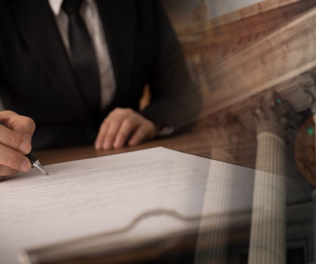 transparent photo showing someone signing a document and a capital building